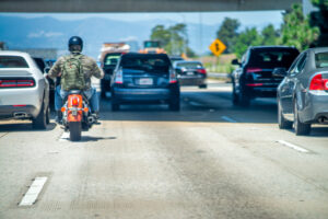 A motorcycle lane splitting while on the freeway.