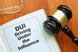 A manual that is titled "DUI Driving Under the Influence" next to a gavel.